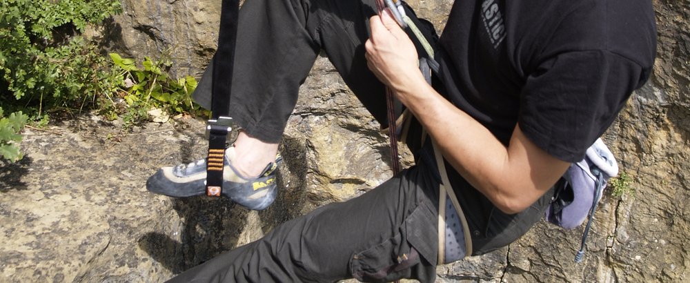 Grimpeur sur une falaise, longe Tybelt reliée à son baudrier